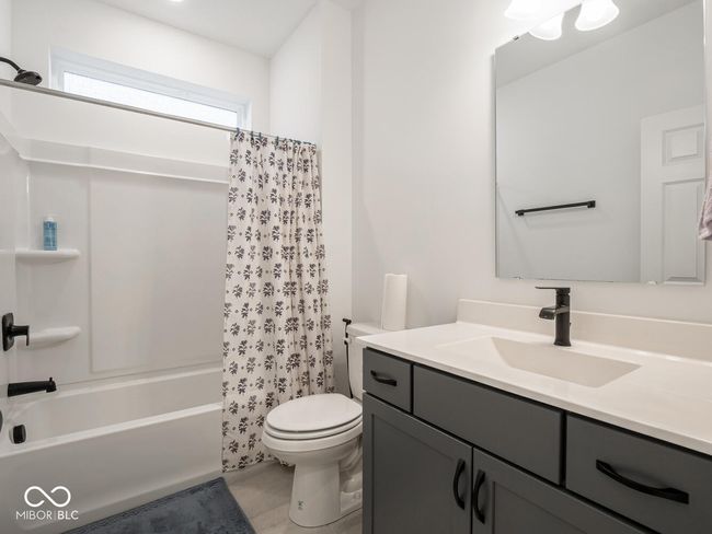 bathroom featuring toilet, shower / bath combo, and vanity | Image 27