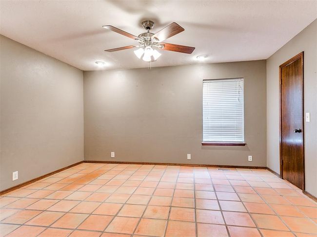 Empty room with a ceiling fan and light tile patterned flooring | Image 32