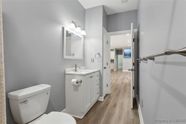 Bathroom with wood finished floors, toilet, vanity, and baseboards | Image 19
