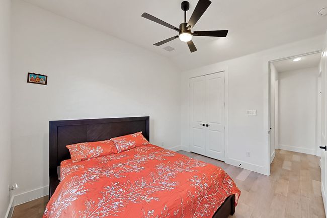 Bedroom with light wood-style floors, baseboards, lofted ceiling, a closet, and a ceiling fan | Image 28