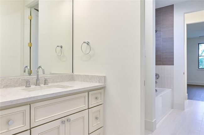 The Jack and Jill bathroom is thoughtfully designed with dual sinks, each featuring sleek quartz countertops, providing both style and practicality for shared use between the two bedrooms. | Image 41
