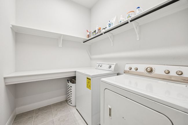 Laundry area featuring washing machine and clothes dryer, baseboards, and light tile patterned floors | Image 10