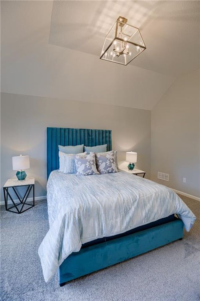Bedroom featuring lofted ceiling, carpet floors, and a notable chandelier | Image 39