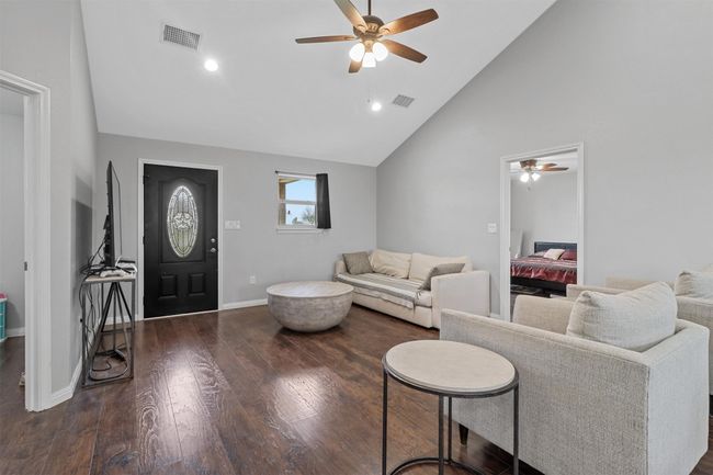 Living room with wood-type flooring, visible vents, baseboards, and a ceiling fan | Image 5