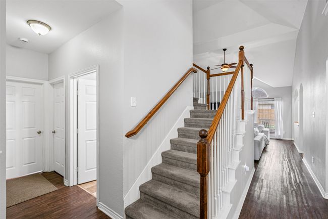 Stairway featuring laminate floors, a ceiling fan, and vaulted ceiling | Image 5