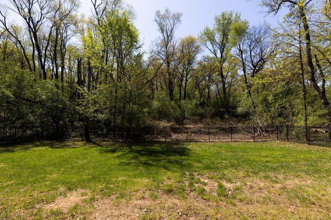 Large fenced backyard surrounded by the privacy of trees. | Image 39