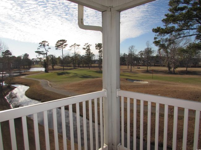 Screen porch with water and golf course view. | Image 35
