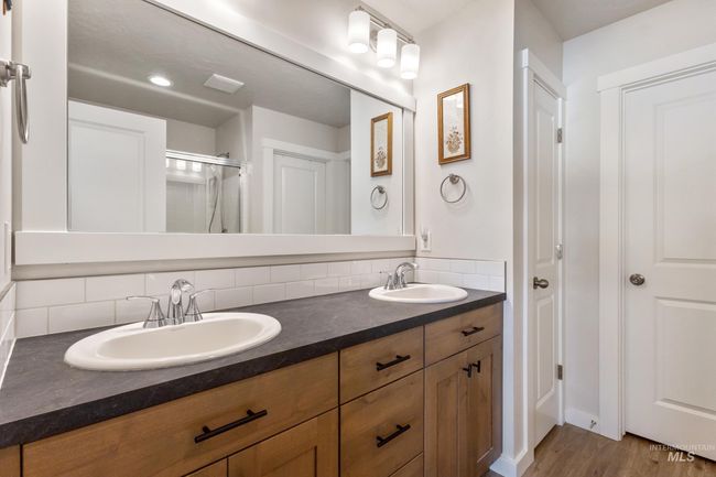 Full bathroom featuring decorative backsplash, double vanity, wood finished floors, and a shower stall | Image 16