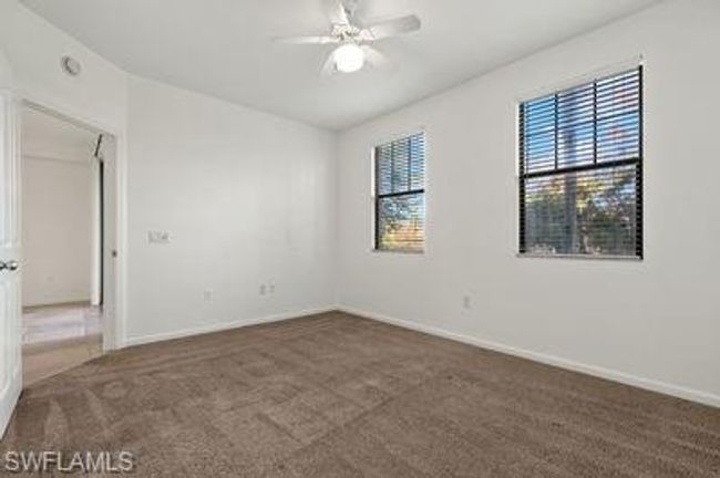 Carpeted empty room with baseboards and a ceiling fan | Image 18