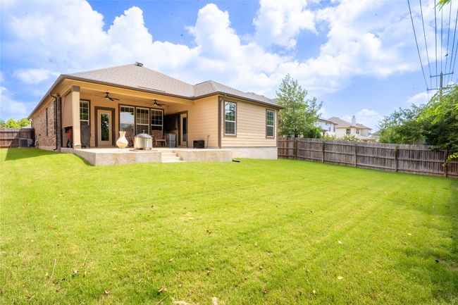 Rear view of house with a ceiling fan, a patio, and a fenced backyard | Image 28