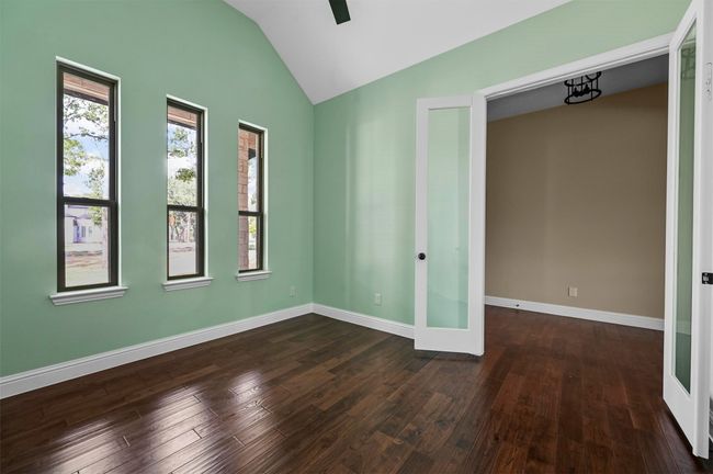 Empty room with lofted ceiling, french doors, dark wood finished floors, and baseboards | Image 18