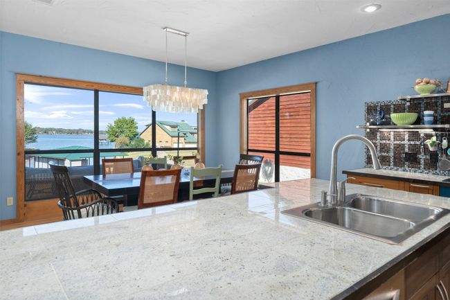Kitchen featuring a water view, sink, light stone counters, and pendant lighting | Image 12