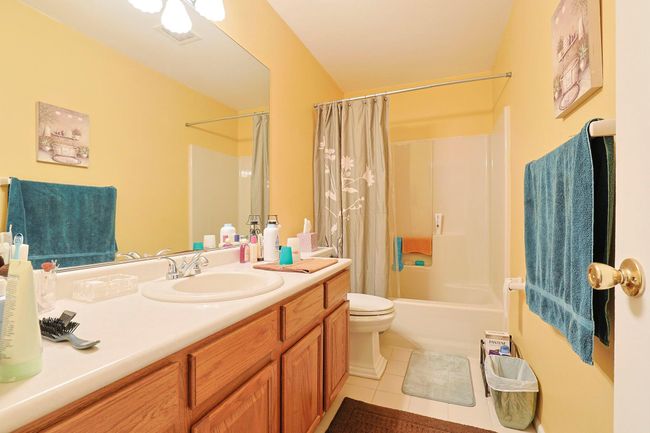 Bathroom with shower / bath combo, tile patterned flooring, vanity, and toilet | Image 15