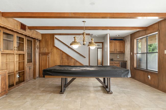 Rec room featuring light tile patterned floors, wooden walls, beamed ceiling, and pool table | Image 27