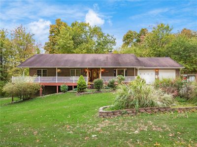 Ranch-style home featuring a front yard and a garage | Image 1