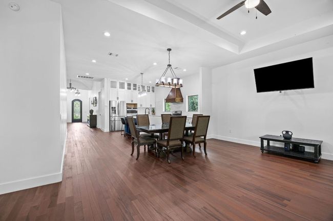 Dining space featuring a chandelier, ceiling fan, recessed lighting, and dark wood-style floors | Image 11