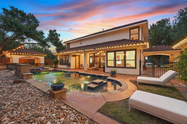 Back of property at dusk featuring stucco siding, a fenced backyard, a tile roof, a patio area, and ceiling fan | Image 38