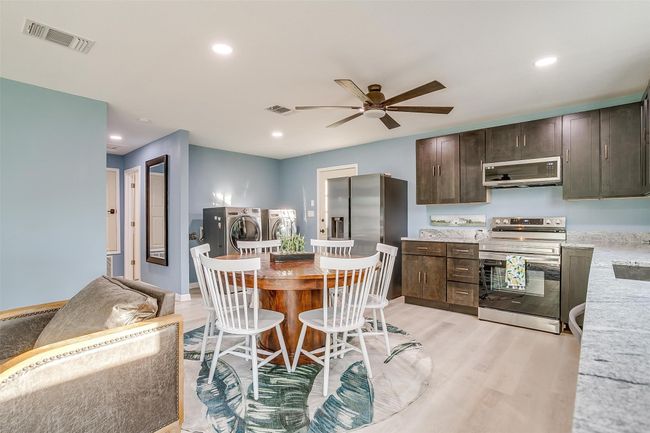 Kitchen featuring washer and clothes dryer, a ceiling fan, stainless steel appliances, and visible vents | Image 17