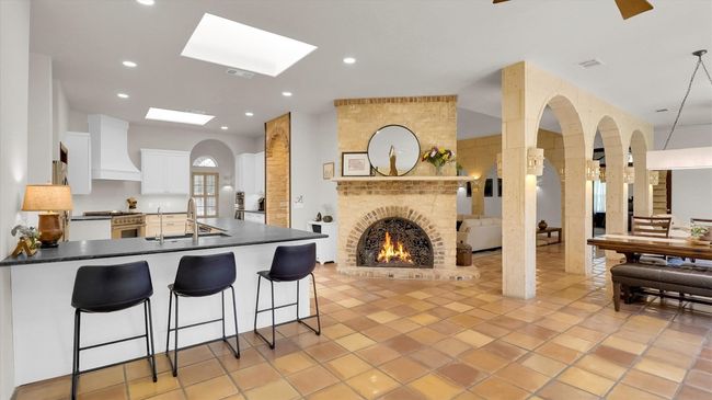 Kitchen featuring leathered granite countertops, stainless steel stove, custom exhaust hood, and a sink | Image 13