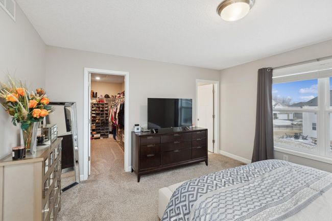 Retreat to your spacious primary suite with a large walk-in closet and private bath featuring a dual vanity, and an oversized shower. | Image 12