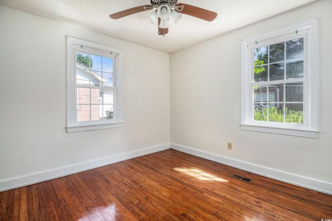 Spare room featuring wood-type flooring, plenty of natural light, a ceiling fan, and a textured ceiling | Image 12