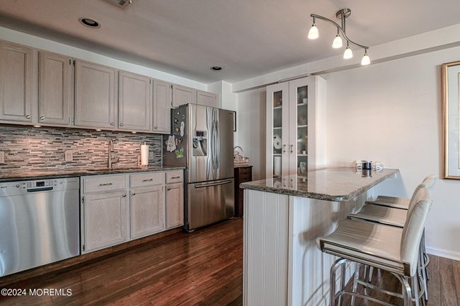 Kitchen with Stone Counters, Stainless Appliances and Breakfast Bar | Image 10
