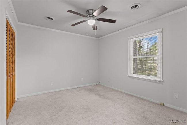 Unfurnished bedroom featuring light carpet, visible vents, a closet, and crown molding | Image 27