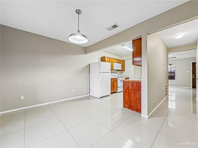 Kitchen with white appliances, pendant lighting, and light tile patterned flooring | Image 5