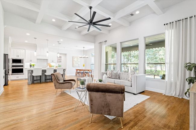 Living area featuring coffered ceiling, light wood-type flooring, a chandelier, beamed ceiling, and recessed lighting | Image 6