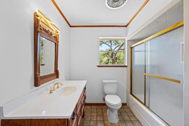 Full bath featuring plenty of natural light, vanity, toilet, and shower / bath combination with glass door | Image 20