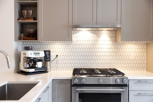 Kitchen featuring gas range, a sink, open shelves, light countertops, and backsplash | Image 32