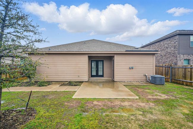 Rear view of house featuring central AC unit, french doors, fence, and a yard | Image 18