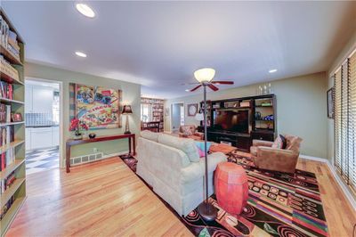 Living room featuring a healthy amount of sunlight, hardwood / wood-style floors, and ceiling fan | Image 2