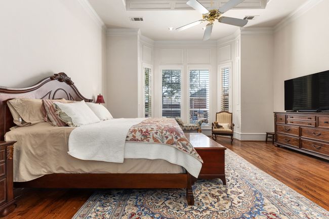 Bedroom featuring a ceiling fan, wood finished floors, and crown molding | Image 18