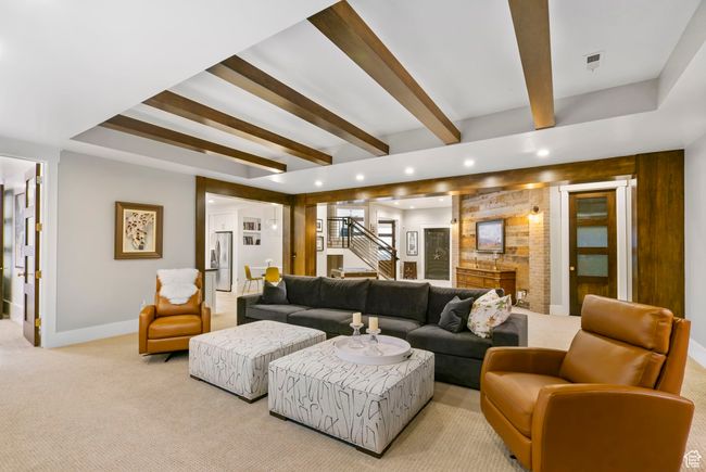 Living area featuring baseboards, beam ceiling, recessed lighting, stairway, and light carpet | Image 86