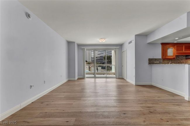 Unfurnished living room with baseboards and light wood finished floors | Image 23