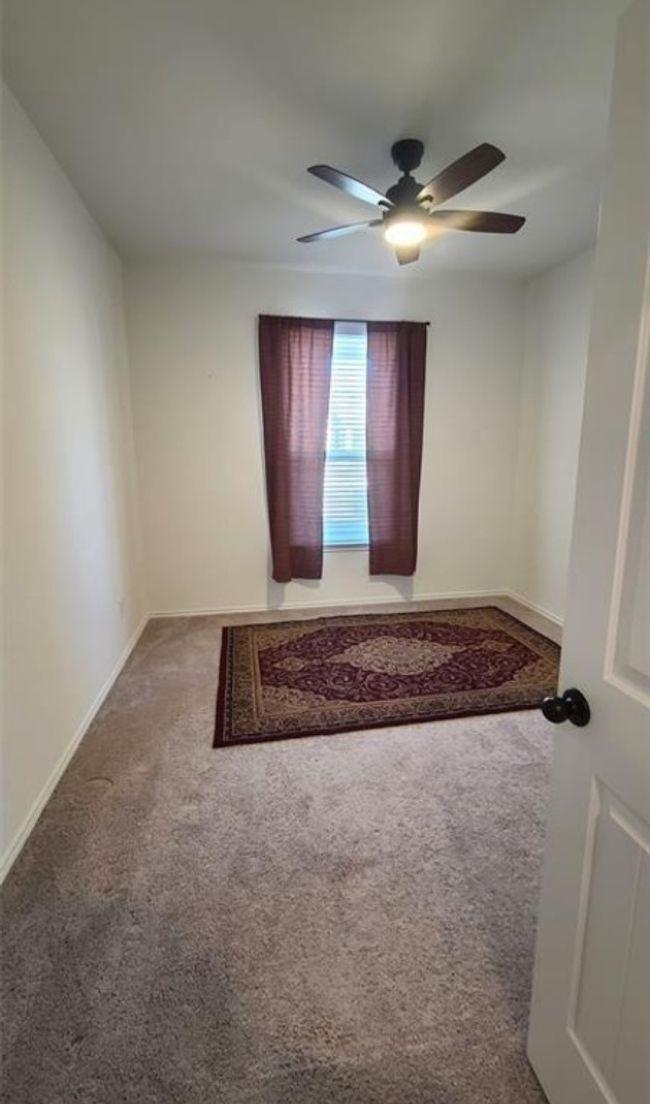 Carpeted spare room featuring a ceiling fan and baseboards | Image 6