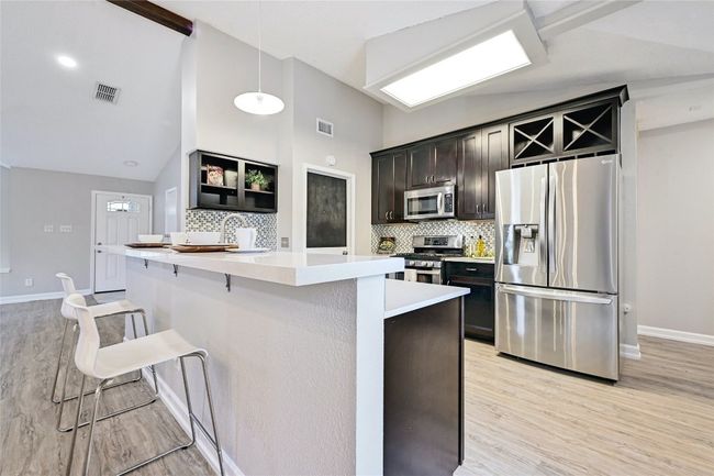 The kitchen features SS appliances, including a gas cooktop and refrigerator. | Image 12