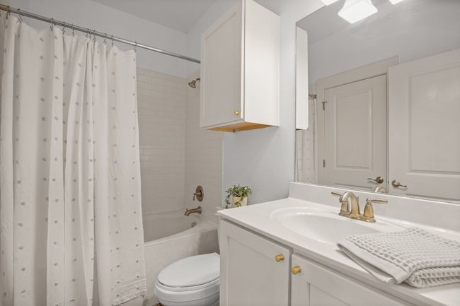 Bathroom featuring vanity and shower / tub combo with curtain | Image 26