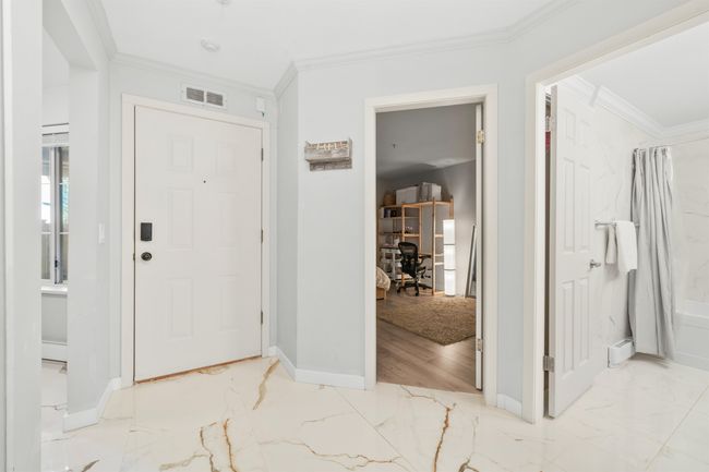 Entrance foyer with marble finish floor, visible vents, ornamental molding, and baseboards | Image 23