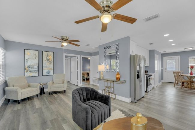 Living room with baseboards, visible vents, light wood-style flooring, and ceiling fan | Image 11