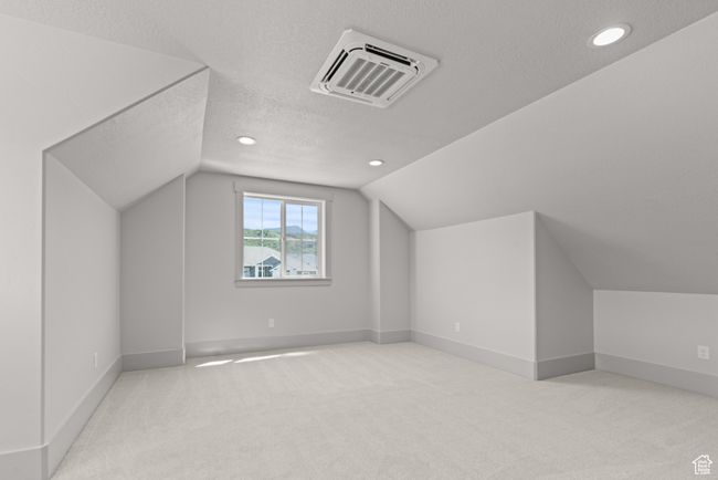 Additional living space featuring a textured ceiling, lofted ceiling, carpet, and recessed lighting | Image 27