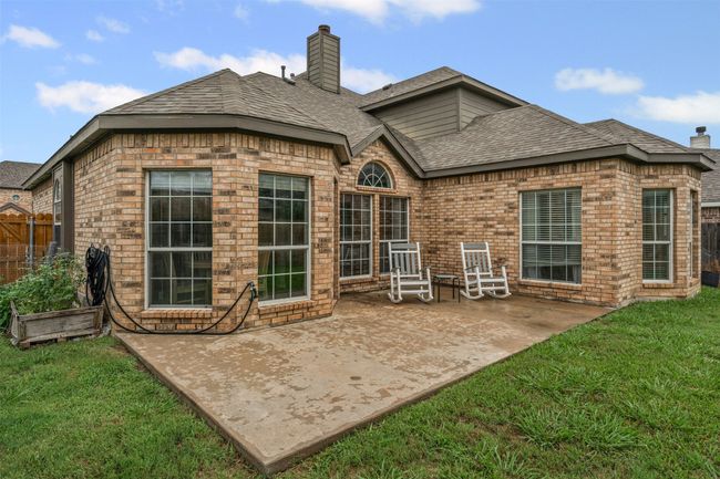 Back of house featuring a chimney, a patio area, brick siding, and a shingled roof | Image 30