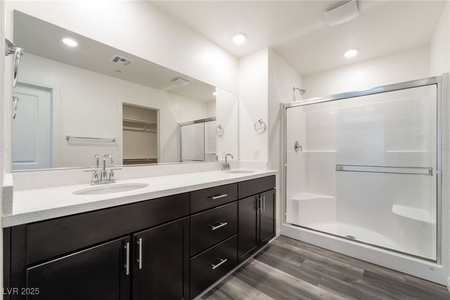 Full bathroom with a shower stall, double vanity, wood finished floors, a walk in closet, and recessed lighting | Image 20