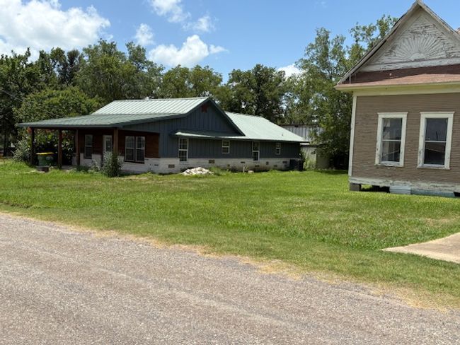 View of side of property with a yard, board and batten siding, and crawl space | Image 18