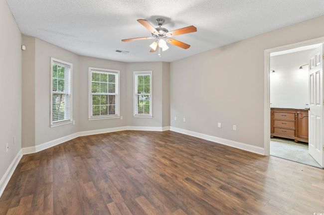 Spare room with plenty of natural light, a ceiling fan, dark wood-type flooring, baseboards, and a textured ceiling | Image 18