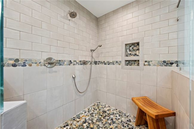 Large primary tile shower with rain head and hand held | Image 51