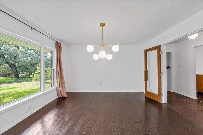 Unfurnished dining area featuring a chandelier, baseboards, and wood finished floors | Image 7