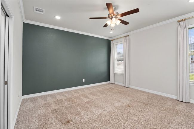 Empty room featuring carpet, a ceiling fan, plenty of natural light, crown molding, and recessed lighting | Image 14