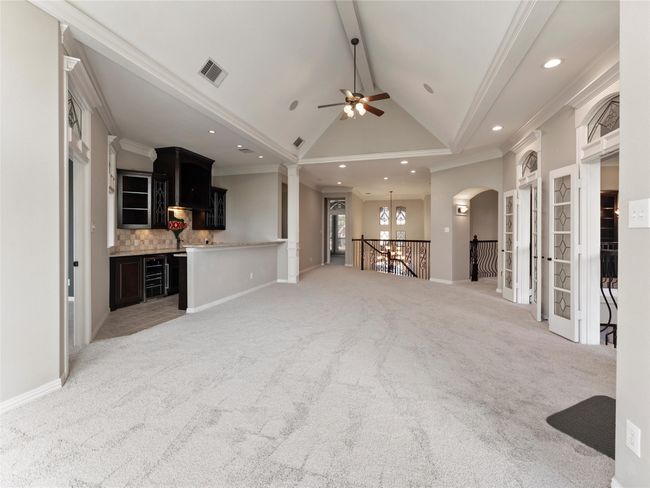 Unfurnished living room featuring recessed lighting, crown molding, light colored carpet, beamed ceiling, and arched walkways | Image 31